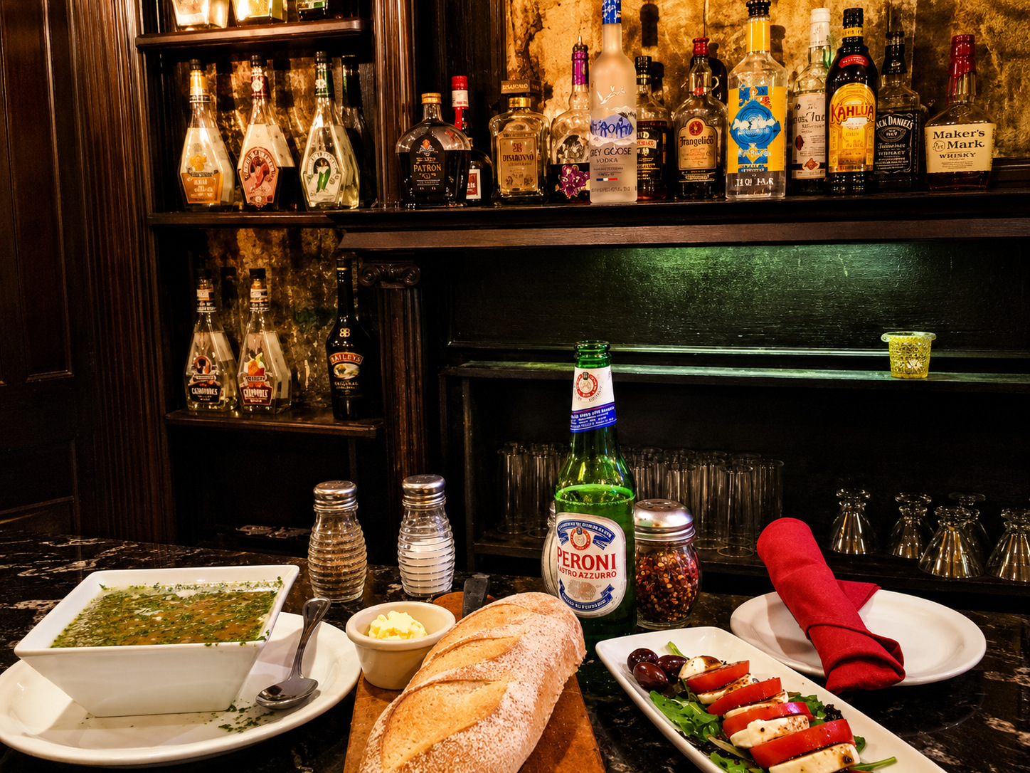 Warm interior bar shelves, bread, Peroni and caprese at Maccheroni Cucina Alfresco